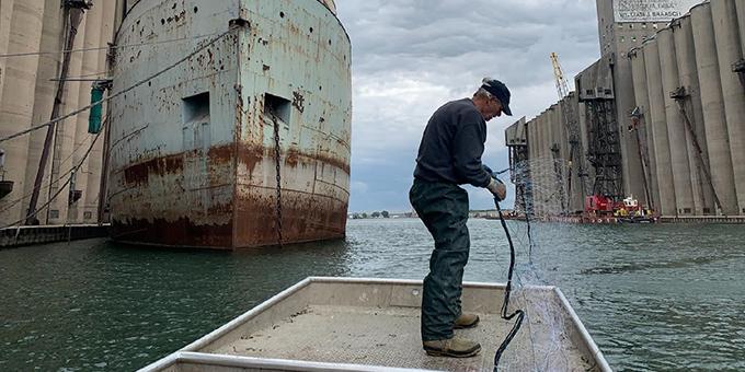 A man on a boat holding a net.