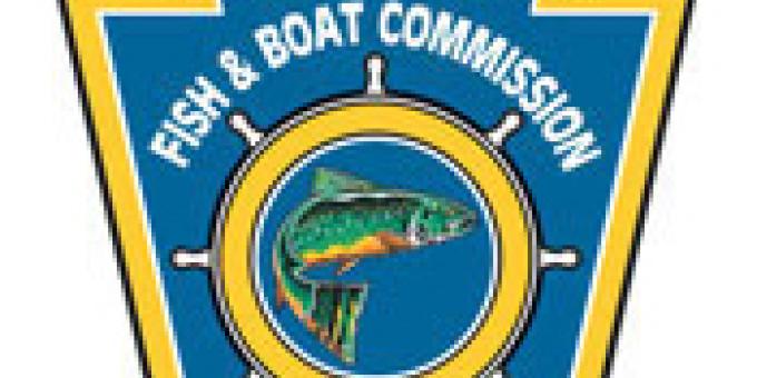 Emblem of the Pennsylvania Fish and Boat Commission showing a fish in the middle of a boat wheel.