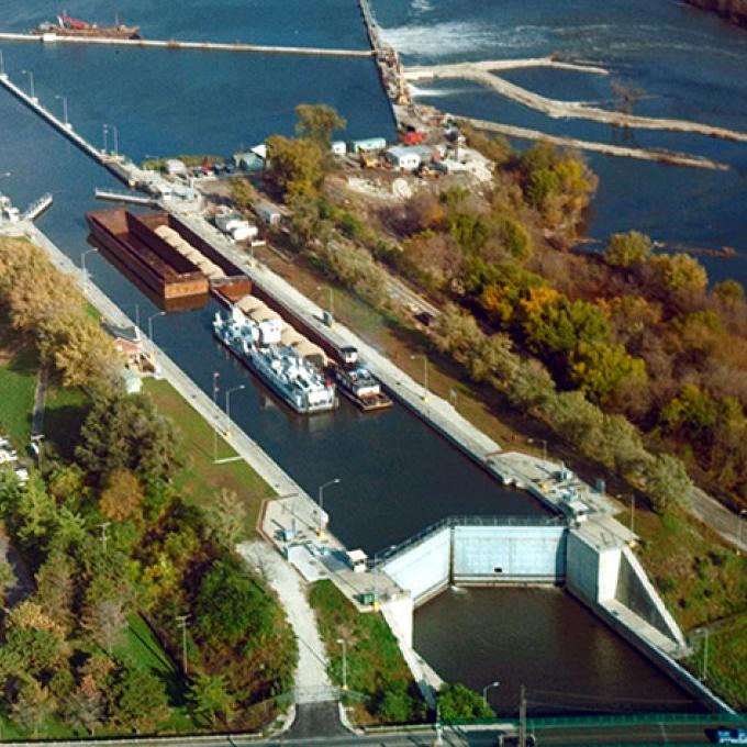 Aerial view of Brandon Road Lock and Dam in Joliet, Illinois. Several barges wait in the lock.