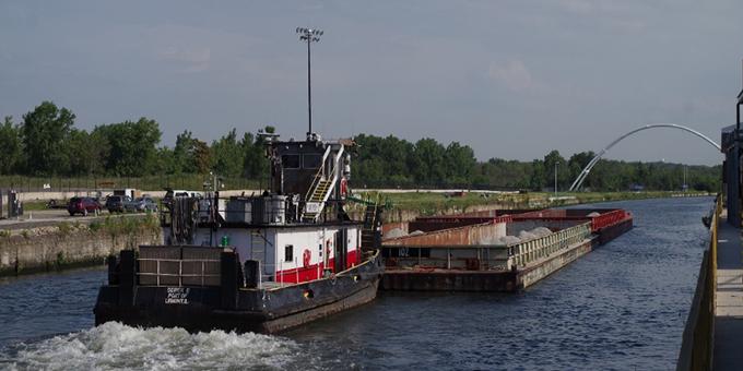 A tow boat pushing a barge on a river.